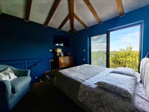 a blue bedroom with a bed and a window at Casa Rosa Istria in Kućibreg