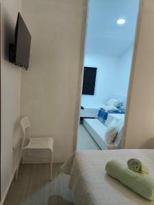 ein Schlafzimmer mit Spiegel, Bett und Fernseher in der Unterkunft Monte da Bárbara in Algoceira