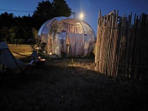 an igloo in a yard next to a fence at Cocoon Reflex'Ô in Escurolles