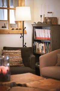 a living room with a couch and a book shelf with books at Appartement & Hotel Innerhofer in Gais