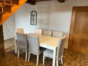 a dining room with a white table and chairs at Einzelzimmer in Jerrishoe