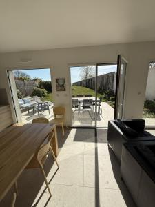 a living room with a wooden table and a patio at Gîte du Flot - Baie de Somme in Boismont