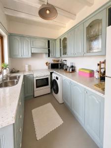 a kitchen with blue cabinets and a washer and dryer at villa kite paros in Pounda