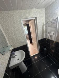 a bathroom with a sink and a toilet and a mirror at Heart of Mtskheta Studio Apartment in Mtskheta