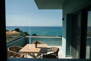 a table and chairs on a balcony with a view of the ocean at Villa Gonates in Limenaria