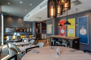 a restaurant with tables and chairs and clocks on the walls at Premier Inn Bremerhaven in Bremerhaven +40 photos