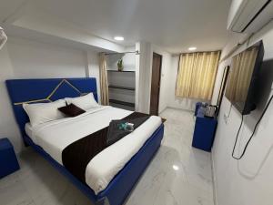 a bedroom with a bed and a television in it at Blue Shell in Chennai