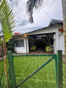 a house with a fence in front of a yard at Recanto do Sol I in Ilha do Mel