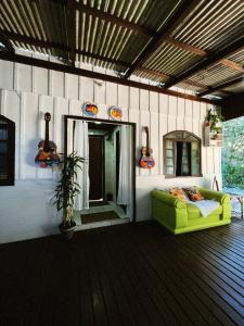a living room with a green couch in a house at Recanto do Sol I in Ilha do Mel