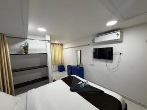 a hospital room with a bed and a flat screen tv at Blue Shell in Chennai