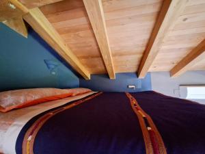 a bed in a room with wooden ceilings at Apartment Rosa Istria in Buje