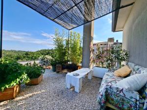 a patio with a couch and a table and some plants at Apartment Rosa Istria in Buje