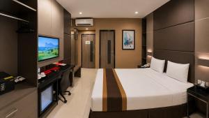 a bedroom with a large bed and a flat screen tv at B Fashion Hotel in Jakarta
