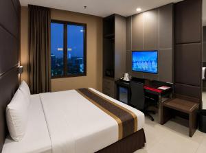 a hotel room with a bed and a desk with a computer at B Fashion Hotel in Jakarta