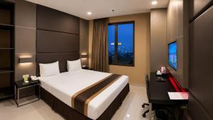 a bedroom with a bed and a desk and a computer at B Fashion Hotel in Jakarta +12 photos