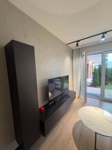 a living room with a flat screen tv and a table at Apartament z Tarasem Parking Smart TV Wi-Fi in Sosnowiec