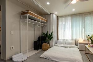 a bedroom with a white bed and a window at 김포공항ㆍ까치산역ㆍ최대11명ㆍ3룸화2ㆍ각방에어컨ㆍ2층독채 in Seoul