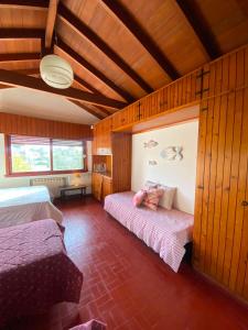 a bedroom with two beds in a room with wooden walls at Cruz del Sur in Pinamar