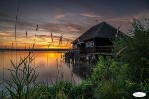 a house on a dock on a lake at sunset at Ferienwohnung Blumäcker Oberbayern in Oberhausen