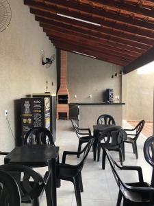 eine Gruppe schwarzer Stühle und Tische in einem Restaurant in der Unterkunft Espaço Vida Nova in Lins