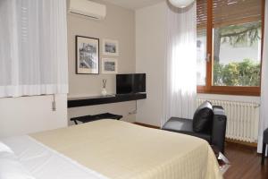 a bedroom with a bed and a chair and a television at Bed And Breakfast 22 Garibaldi Home in Riccione