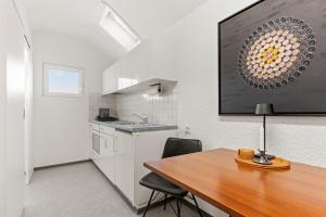 a kitchen and dining room with a wooden table at peaceful tiny house near forest in Rorschacherberg +19 photos