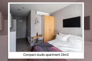 a bedroom with a bed and a desk and a tv at 348 Suites Short Stay in The Hague