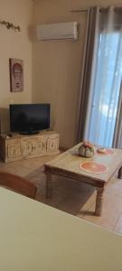 a living room with a coffee table and a flat screen tv at Villa Bianca in Kremasti