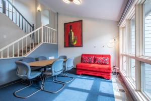 a room with a table and chairs and a red couch at The Woods 8 in Copper Mountain