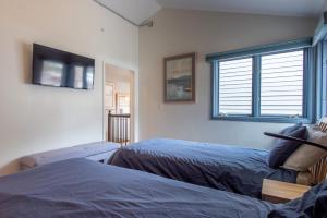 a bedroom with two beds and a tv on the wall at The Woods 8 in Copper Mountain