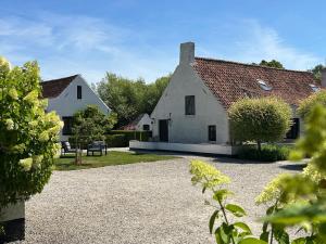 a large white house with a gravel driveway at Stee 23 in Hertsberge