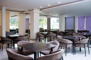 a restaurant with tables and chairs and purple walls at Hotel Kilimanjaro in Luanda