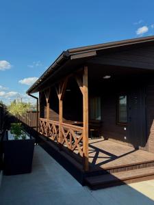 a house with a porch with a wooden deck at Hotel Voyage Вояж in Uman