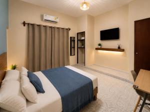 a bedroom with a bed and a desk and a television at Suites Puerto 201 in Veracruz +15 photos