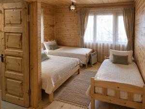 a bedroom with two beds and a window at Ioane's Chalet in Mestia