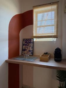 a shelf in a room with a window and a picture at The Beach House in Vasilika
