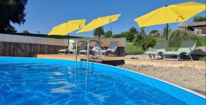 a swimming pool with two yellow umbrellas and chairs at Cezanne in Douzains