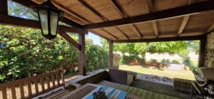 an outdoor patio with a table and a wooden ceiling at Cezanne in Douzains