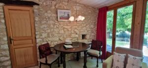 a dining room with a table and chairs and a stone wall at Cezanne in Douzains +23 photos