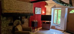 a living room with a fireplace and a television at Monet in Douzains