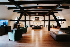 a large living room with a couch and a tv at Farmer Hotel Basedow & Spa in Basedow