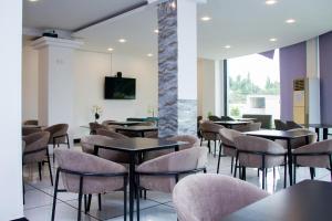 a restaurant with tables and chairs and a tv on a wall at Hotel Kilimanjaro in Luanda