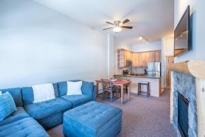 a living room with a blue couch and a kitchen at Copper Springs Lodge 404 in Copper Mountain