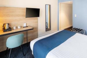 a bedroom with a bed and a desk and a television at Best Western Hotel Fontaine Argent in Besançon