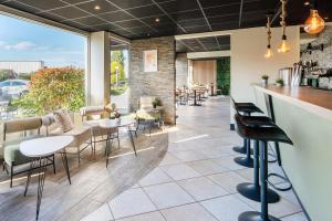 a bar in a restaurant with tables and chairs at Sure Hotel by Best Western Dijon Sud in Chenôve