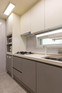 a kitchen with white cabinets and a sink at 김포공항ㆍ까치산역ㆍ최대11명ㆍ3룸화2ㆍ각방에어컨ㆍ2층독채 in Seoul +22 photos