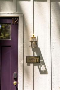 a purple door with a sign next to a purple door at Maison Foxglove - Petite Acres Chateau in New Buffalo
