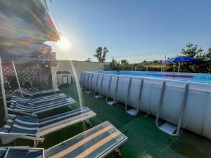 a row of lounge chairs next to a swimming pool at Casa Gli Allori in Iglesias +28 photos