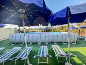 a group of chairs and umbrellas next to a pool at Casa Gli Allori in Iglesias