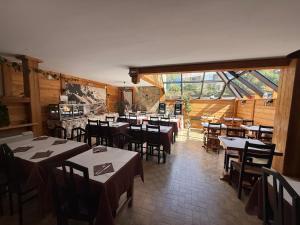 a restaurant with tables and chairs in a room at Hôtel Restaurant La Pendine in Puy-Saint-Vincent